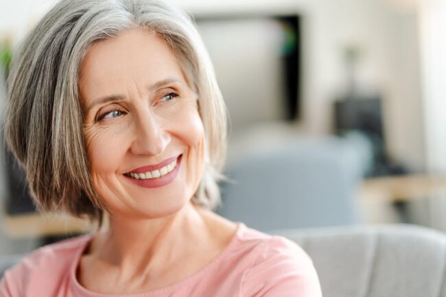 a woman smiling and showing how the Best Dental Implants in Adelaide do their job